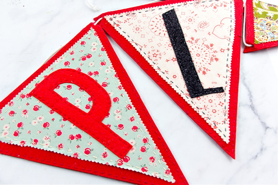a diy playroom garland that's handmade using felt and fabric