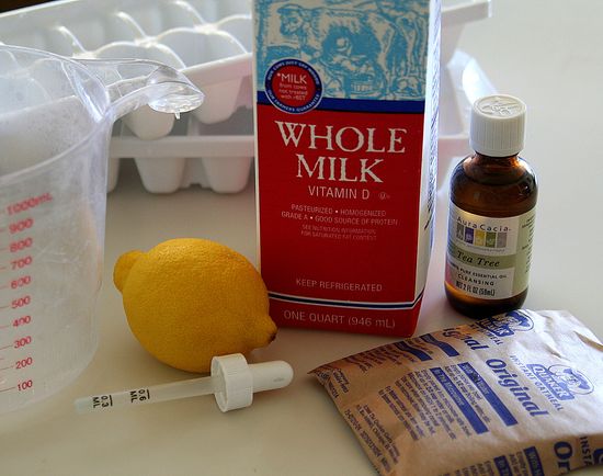 Ingredients to make homemade face cleanser including oatmeal, lemon, tea trea oil, and whole milk