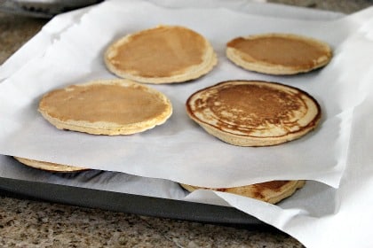 pancakes layered between sheets of parchment paper for freezing