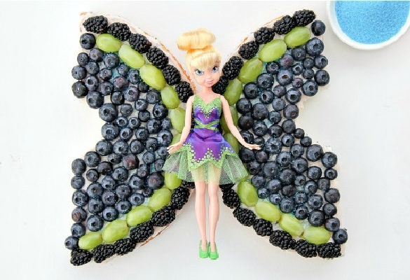 an angel food and fruit cake with Disney's The Pirate Fairy doll on top