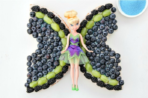 an angel food and fruit cake with Disney's The Pirate Fairy doll on top
