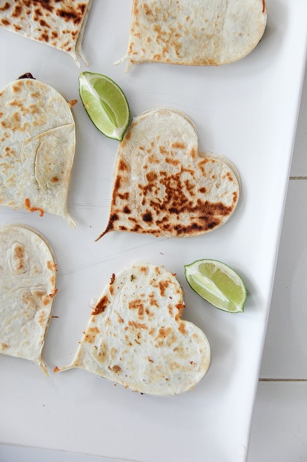 heart shaped quesadillas with lime wedges on a white tray