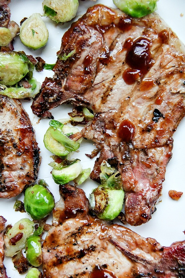 pork chops on a white tray with brussels sprouts