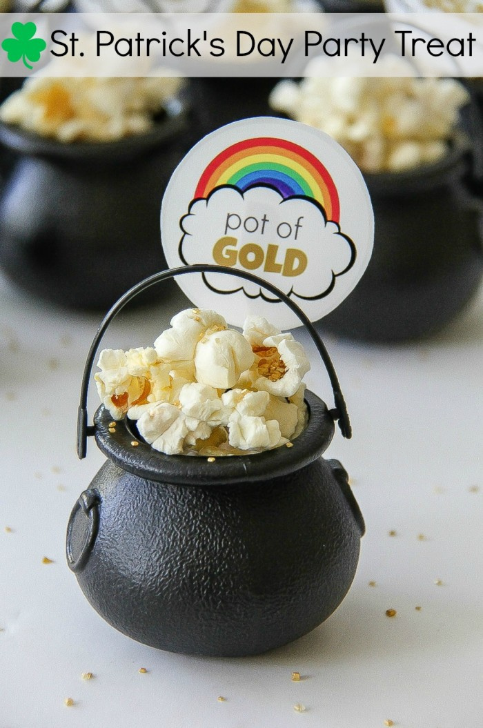 black pot filled with popcorn and a pot of gold paper rainbow on top