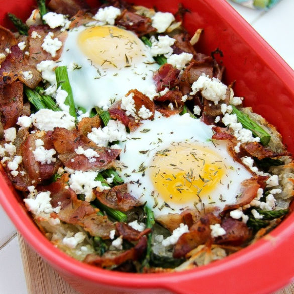 a casserole dish with baked eggs, bacon, asparagus