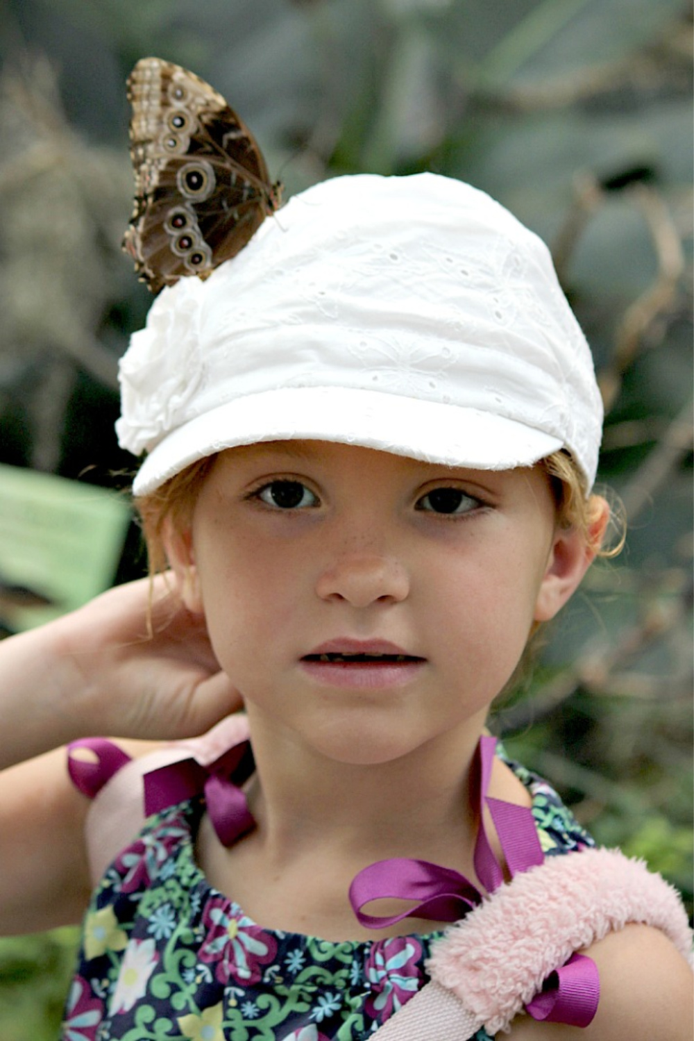 a girl with a butterfly on her hat