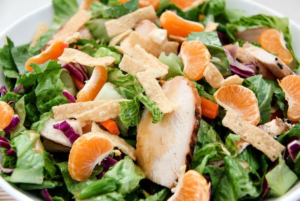 grilled chicken and mandarin orange salad with wontons, carrot strips, and purple cabbage
