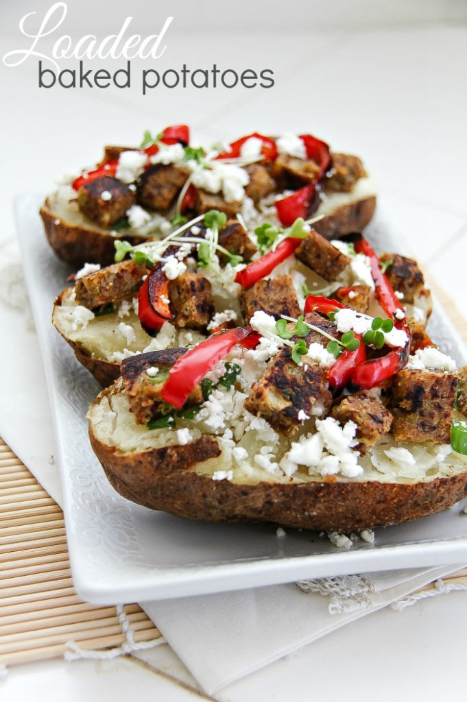 baked potatoes topped with red peppers, feta cheese, and vegetable patties