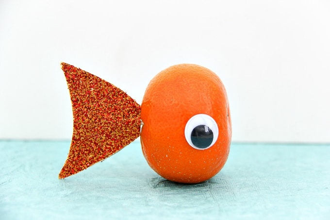 a healthy fish snack for kids that's made out of a mandarin and craft supplies.