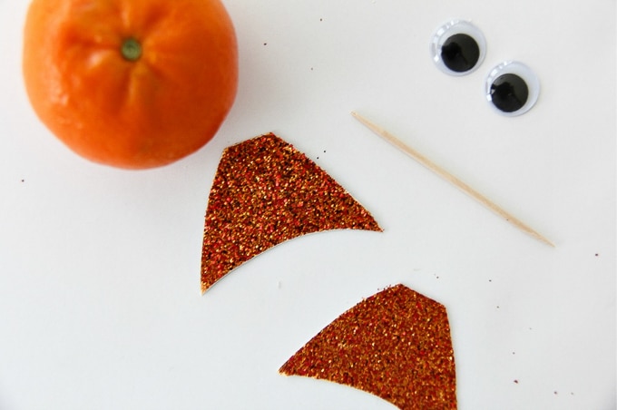 a mandarin, with two fish tails made out of orange cardstock and googly eyes to make a fun fish snack with fruit