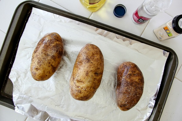 russet potatoes on a baking tray lined with parchment paper