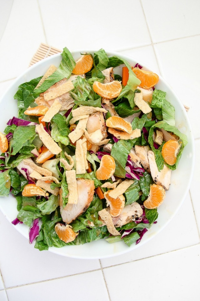mandarin orange and grilled chicken salad in a bowl with wontons, purple cabbage and lettuce