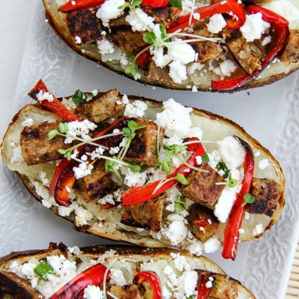 baked potatoes topped with vegetable patties, red pepper and feta cheese
