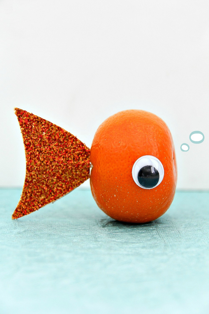 a mandarin with an eye and cardboard fish tail