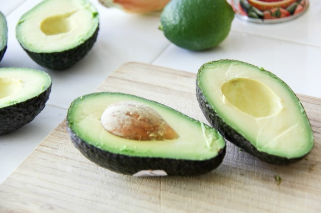 avocados cut in half on a cutting board