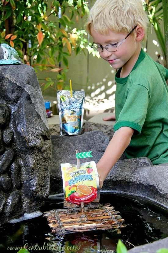 boy playing with a stick raft in water