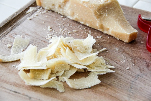 freshly shaved parmesan cheese on a cutting board