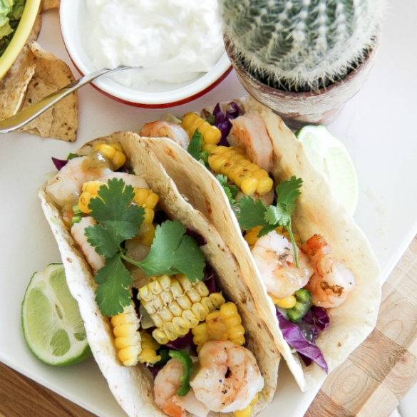 shrimp and corn tacos with a bowl of sour cream