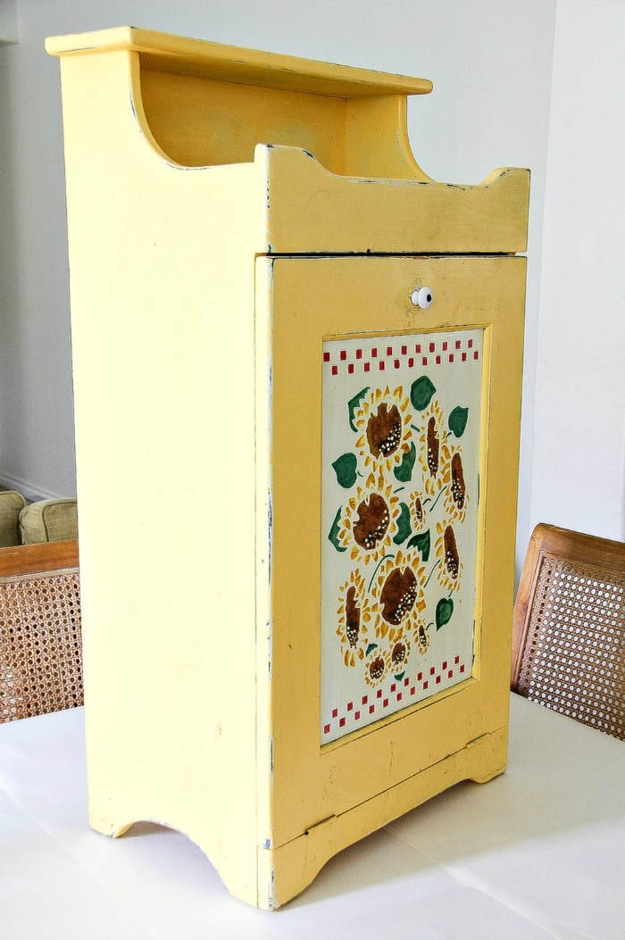 trash can cabinet painted yellow with sunflowers