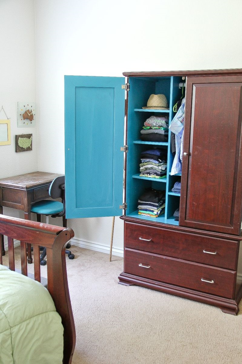 a dark wood armoire painted blue inside for a boys bedroom