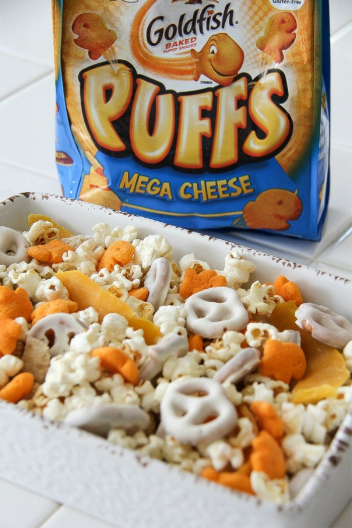 a bag of goldfish puffs behind a gluten-free snack mix in a bowl