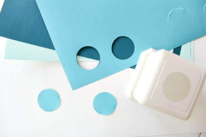 a hole punch with blue circles cut out of card stock