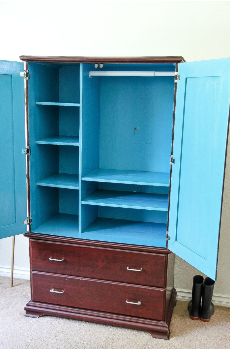 a dark wood armoire painted bright blue inside