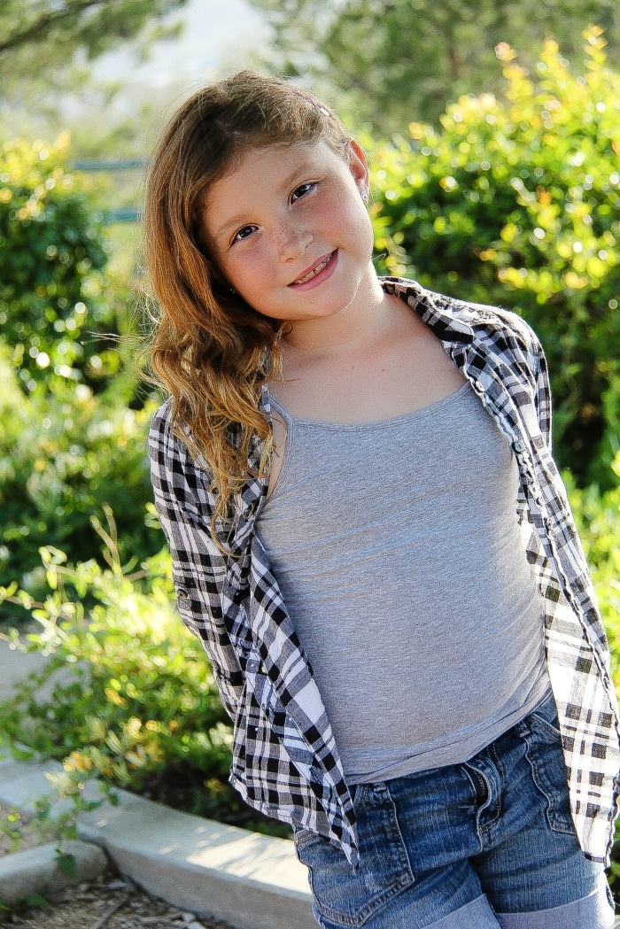 girl wearing a grey tank with black and white check shirt