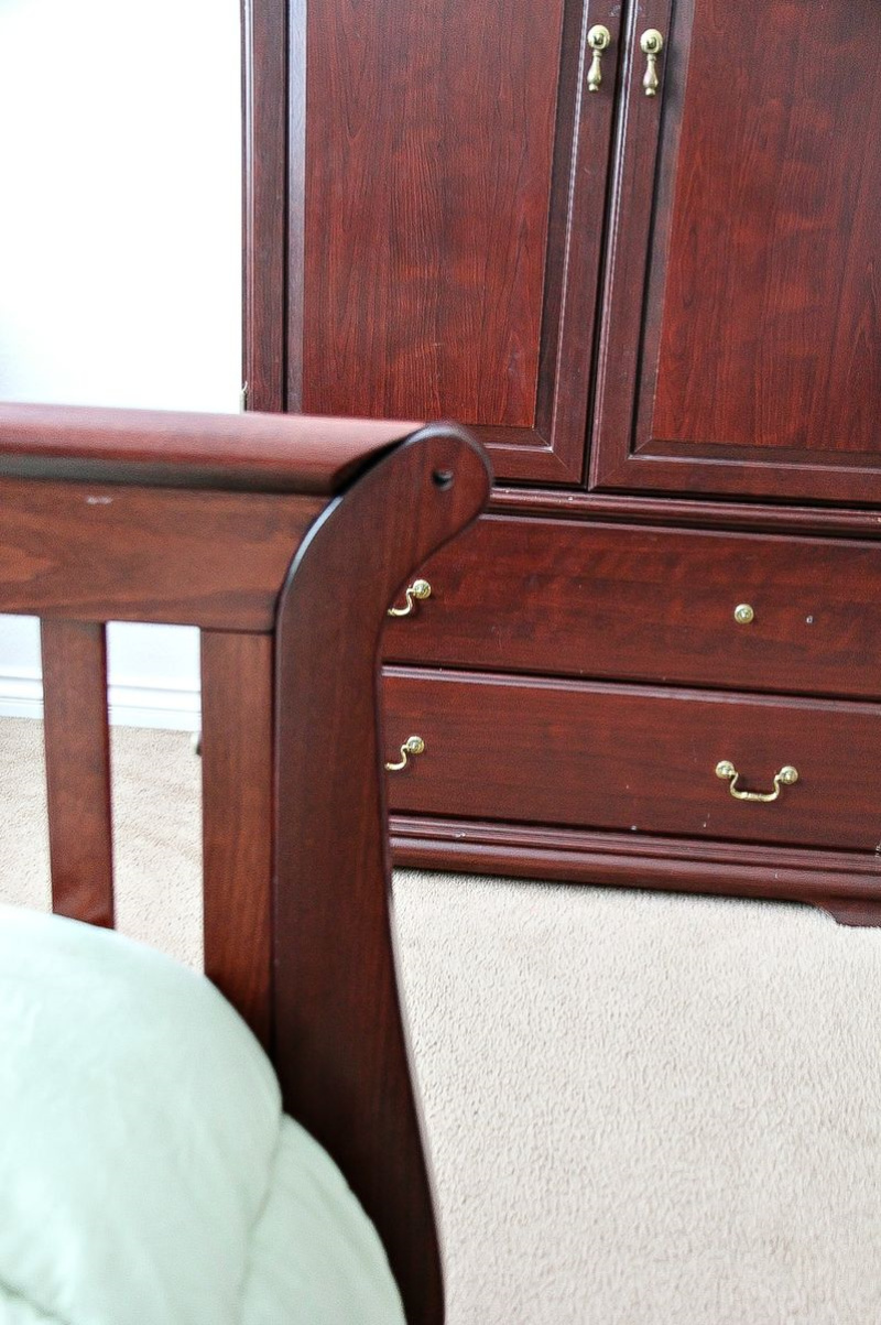 dark wood armoire and bed frame in a bedroom