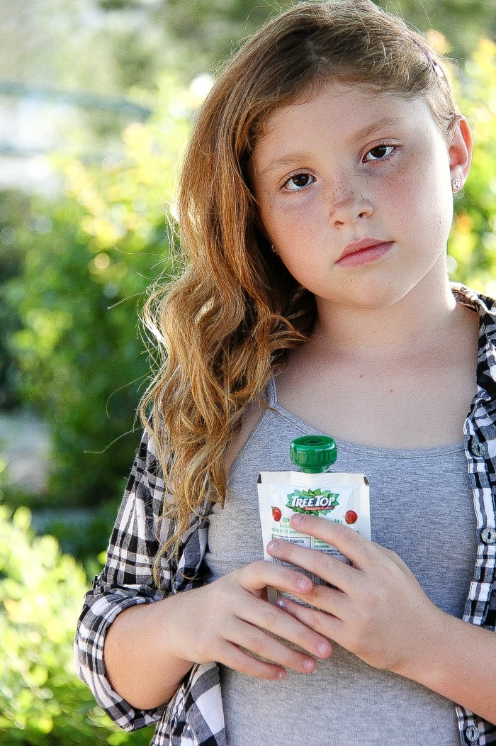 girl wearing a grey tank and black and white checked shirt