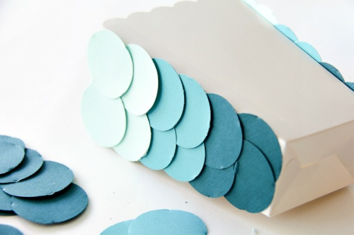 blue ombre circles being attached to a cardboard snack tub