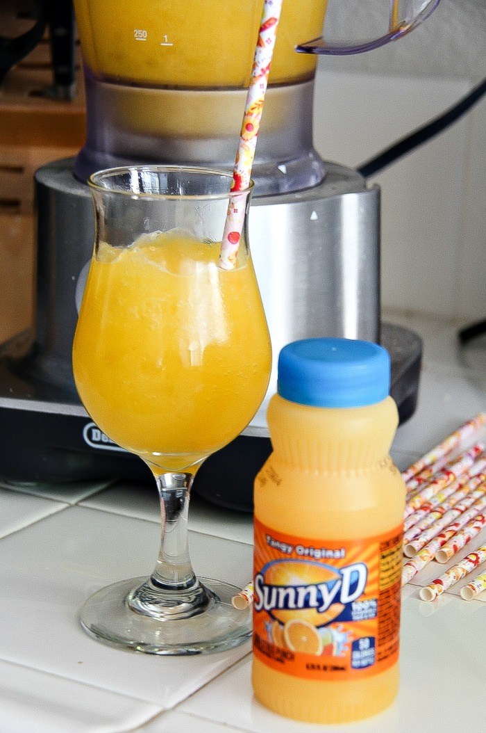a bottle of SunnyD and some in a glass with a straw