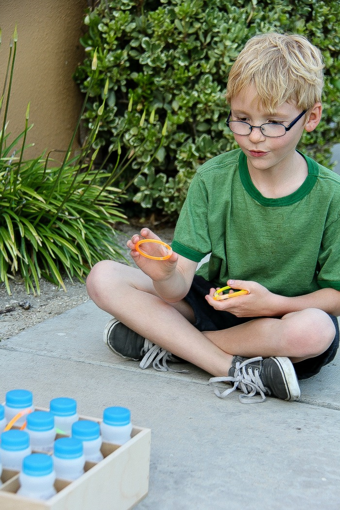 a boy playing a handmade ring toss game