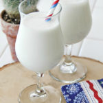 a vanilla milkshake with red white and blue straw and napkin