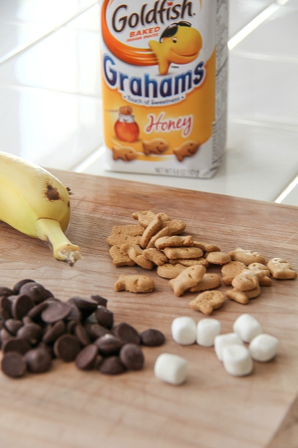 honey graham goldfish crackers with chocolate chips, marshmallows and a banana