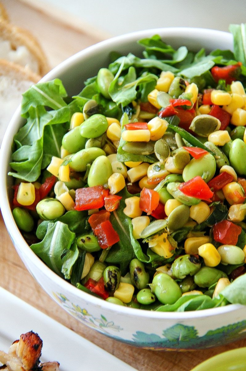 salad in a bowl with greens, edamame, red bell pepper and corn