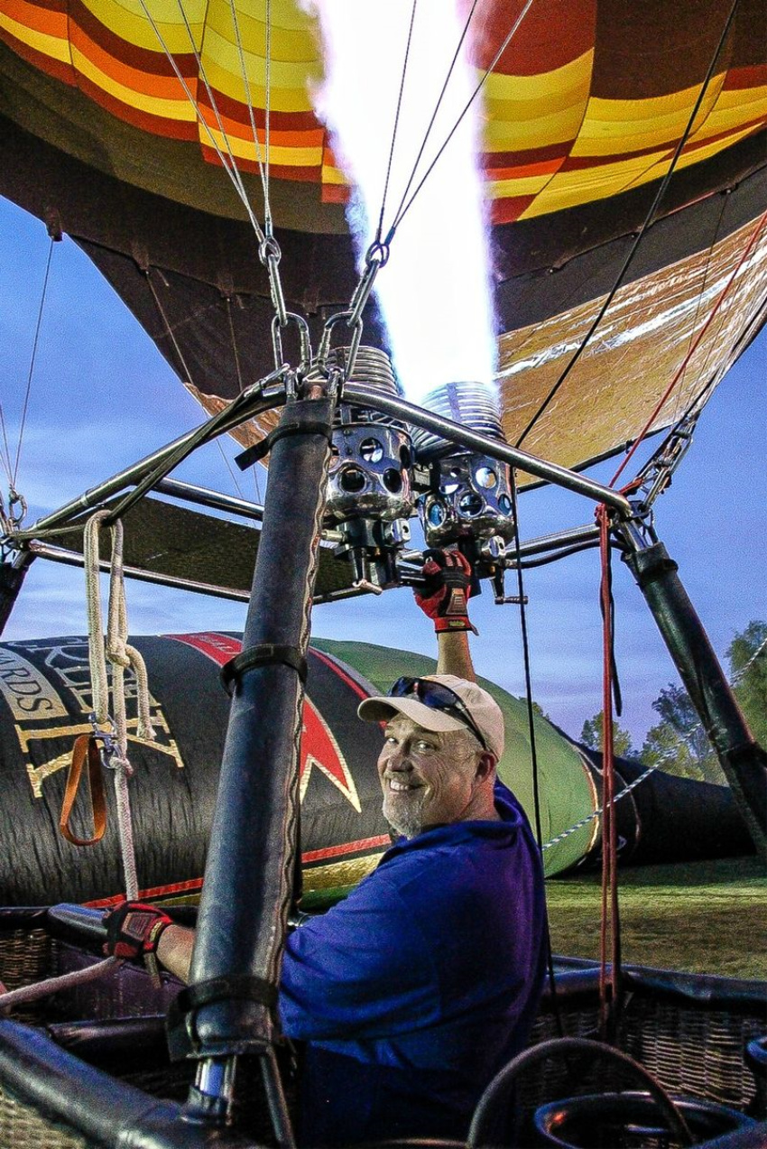 a man in a basket with a hot air balloon being inflated