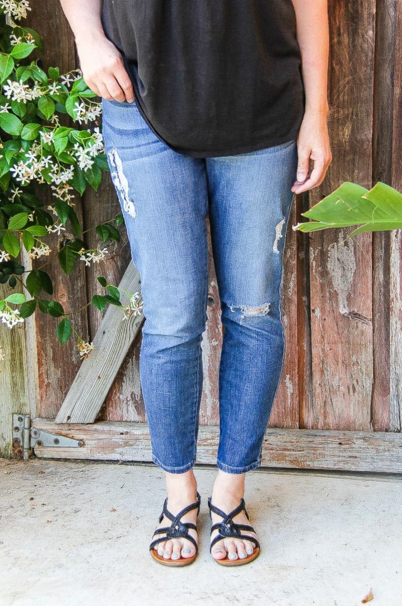 woman in blue jeans with black tank and black sandals