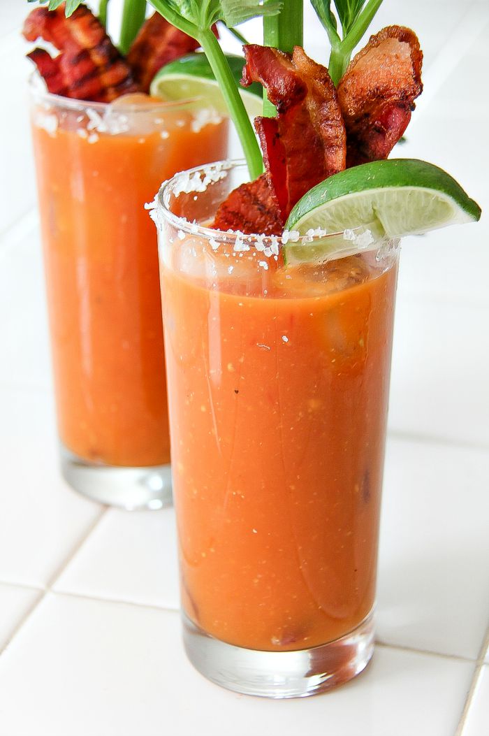 bloody mary in a tall glass with bacon, lime, and celery