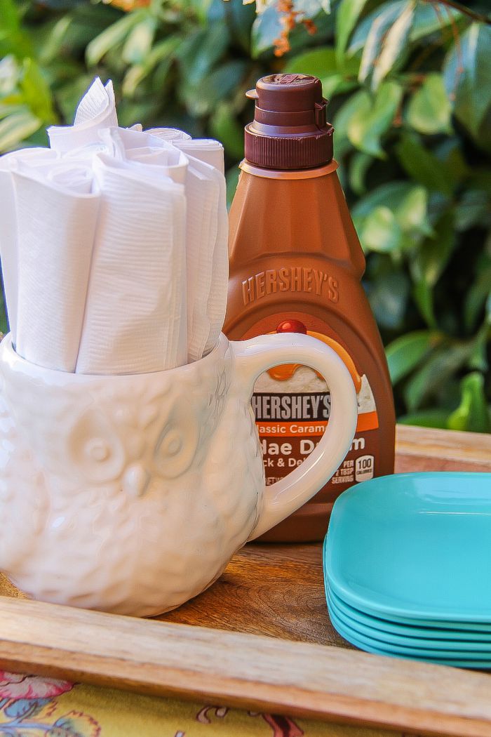 napkins in a cup and Hershey's caramel syrup for a s'mores bar