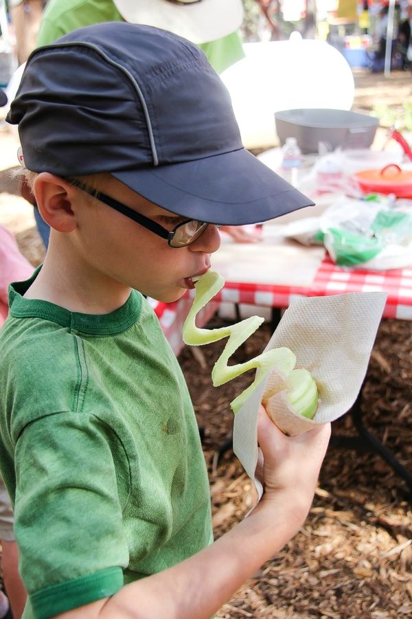 boy eating a spiral apple from an apple corer