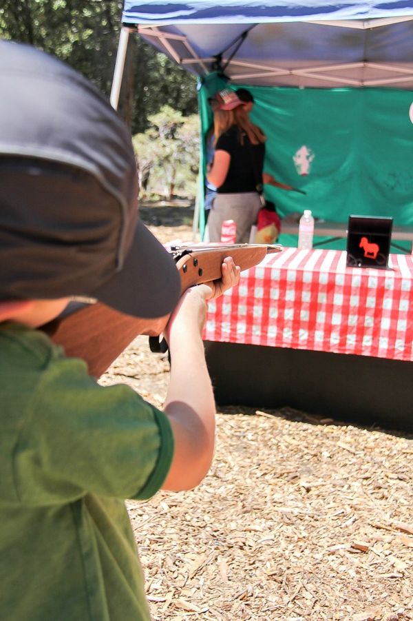 boy shooting a wood elastic band gun at a target