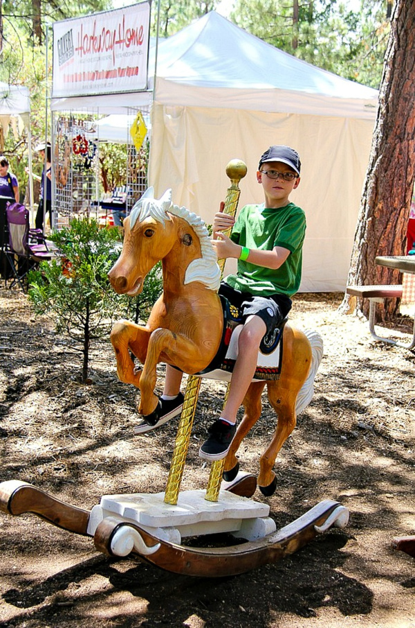 boy riding a hobby horse outdoors