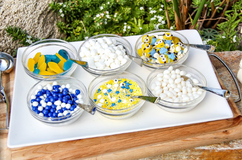 blue, yellow, and white ice cream toppings in glass bowls