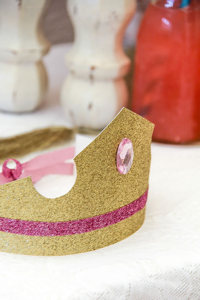 gold cardboard princess crown with a pink ribbon and gem