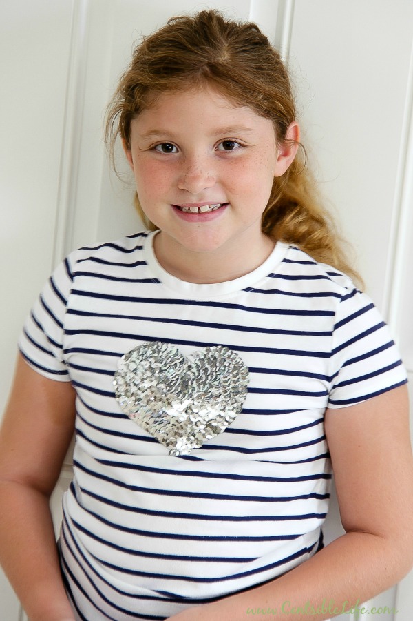 girl wearing a black and white stripe tee with a silver sequin heart on it