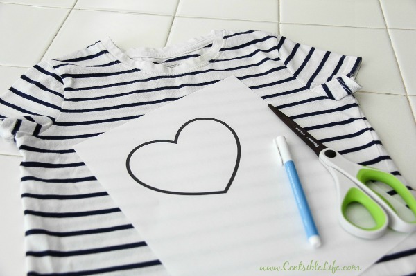 a girls black and white tee with a heart template, pen, and scissors