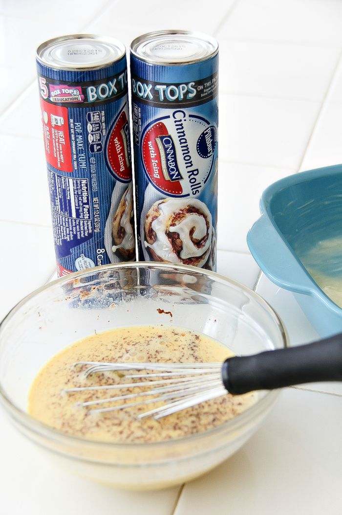 tubes of cinnamon rolls and a bowl of eggs being whisked