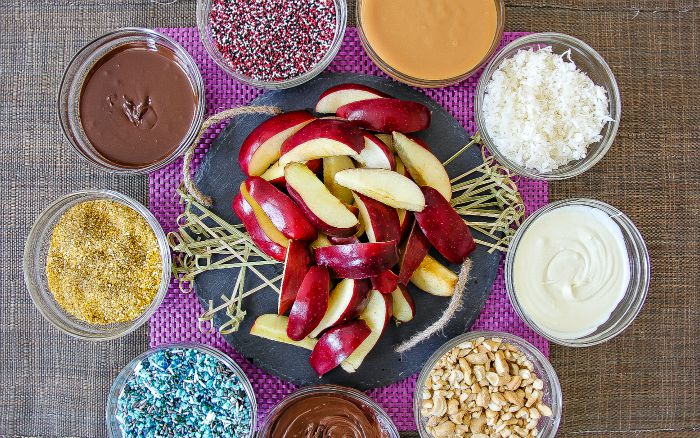 apple slices with dipping sauces and sprinkles