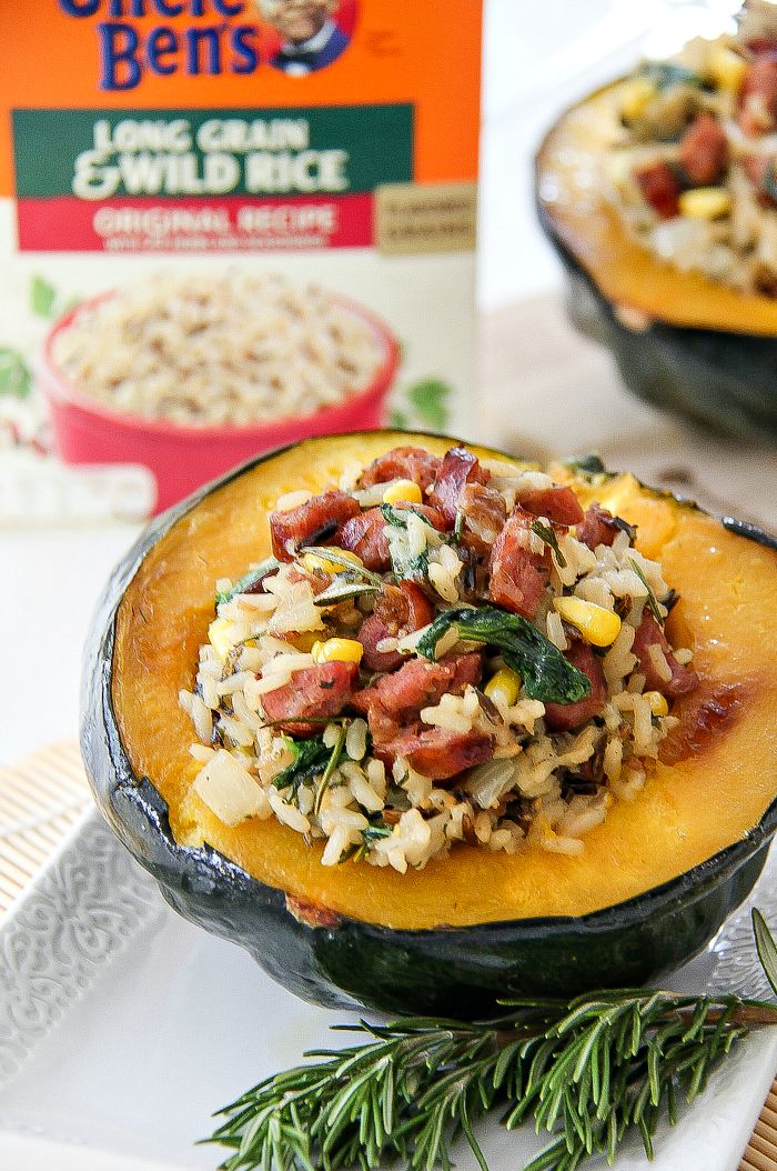 acorn squash stuffed with sausage and rice with a box of uncle bens wild rice